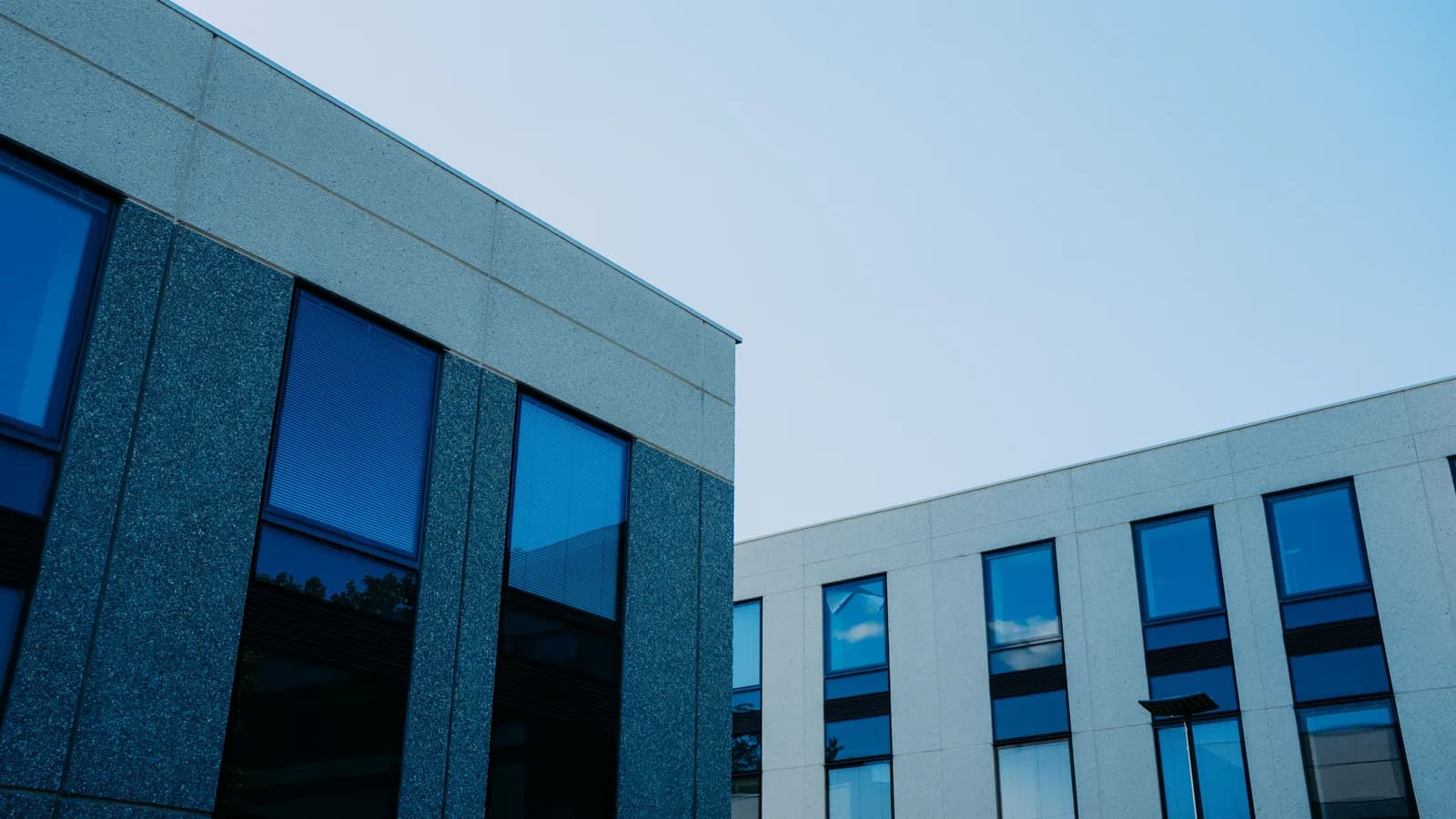 From below of contemporary office buildings with reflection in windows located in city