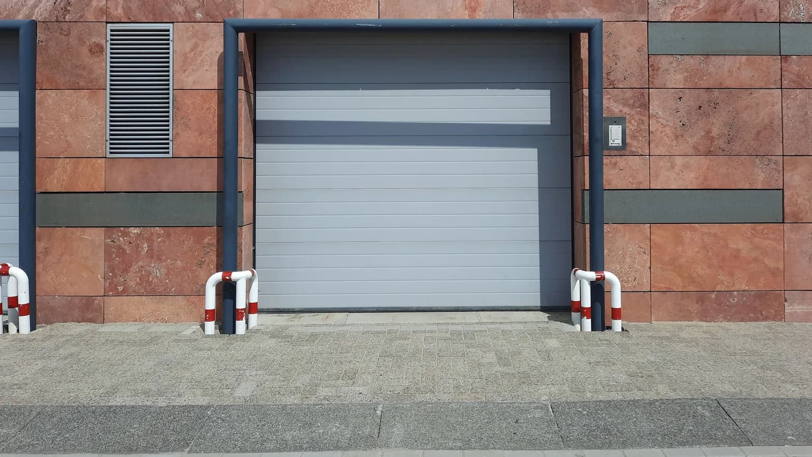 Front view of a modern urban garage entrance with clear signage in natural light.