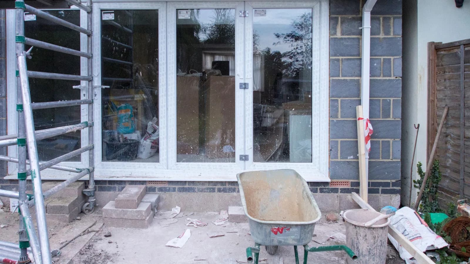 A construction site showcasing home renovation with scaffolding and tools.