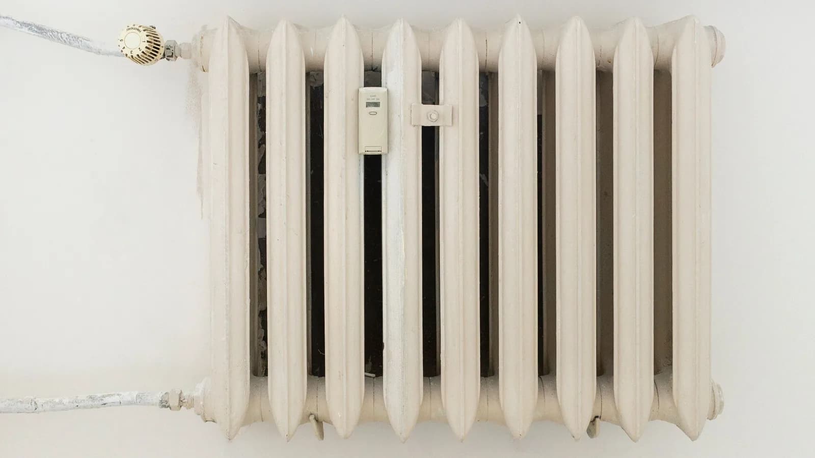 White wall-mounted radiator beneath a window