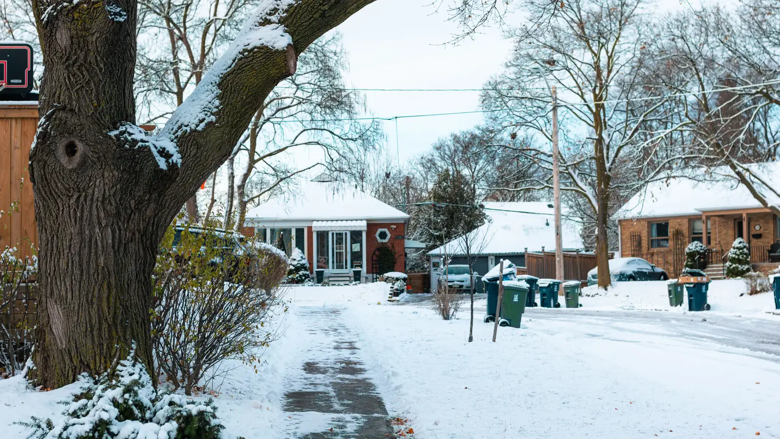 Cleared sidewalk through a snow-covered residential neighborhood