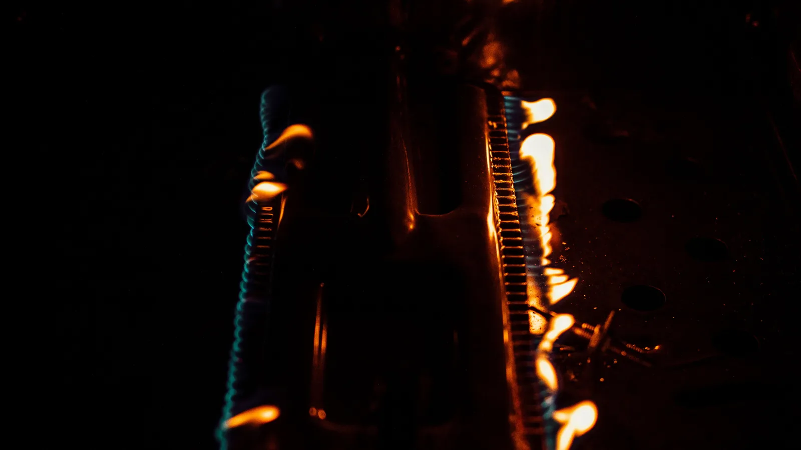 Close-up of flames on a gas burner. Dark and intense atmosphere with glowing fire.
