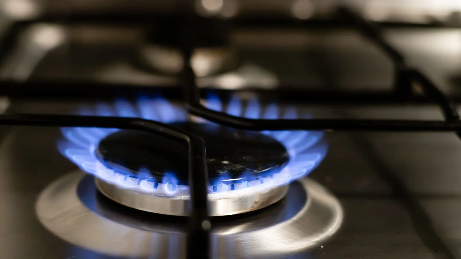 A detailed view of a blue flame on a stove, showcasing energy and heat.