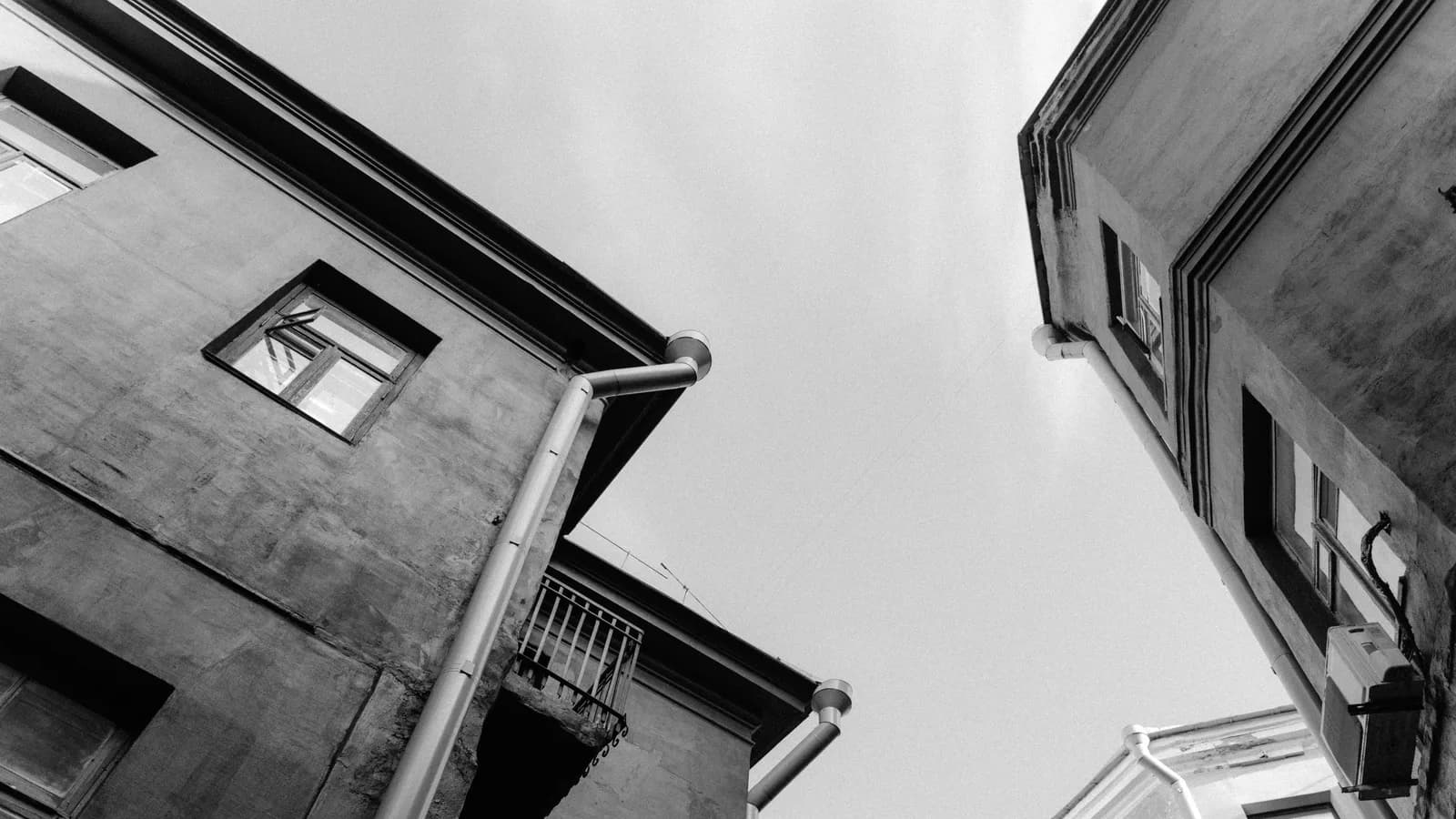 A low angle shot of urban buildings with a vintage architectural style in black and white.
