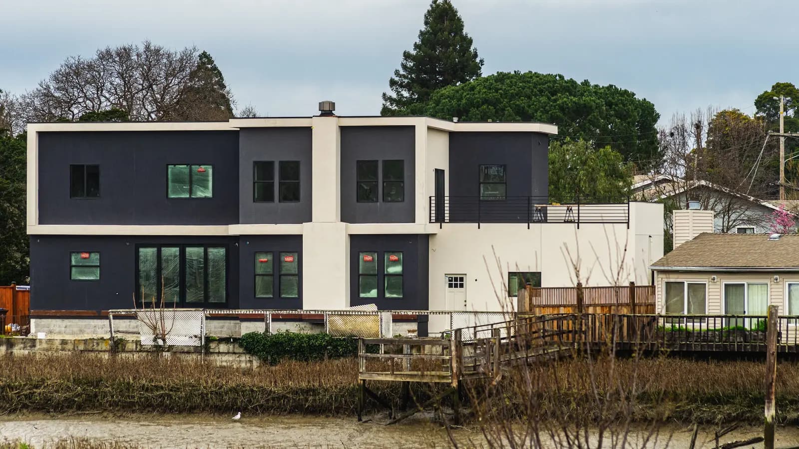 Contemporary two-story house near river with fresh architecture.