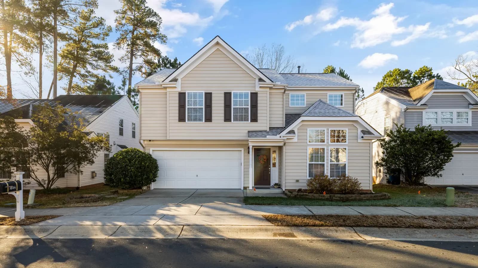 Beautiful modern suburban house with garage and front lawn on a sunny day.