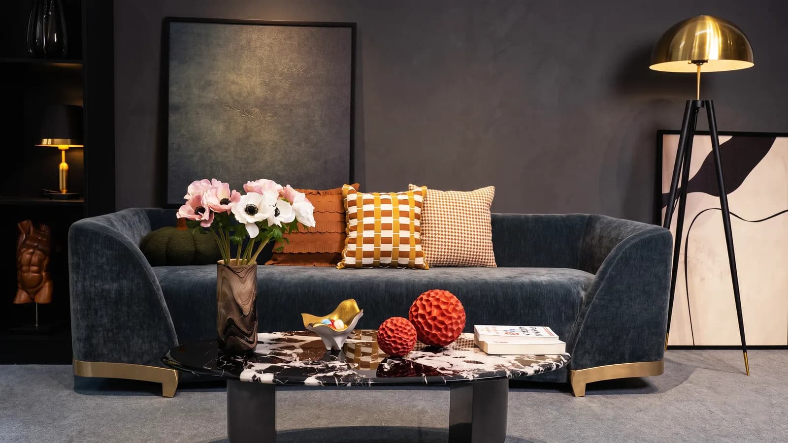 Blue sofa with a gold floor lamp and a small table lamp on a shelf; no ceiling fixture is visible.