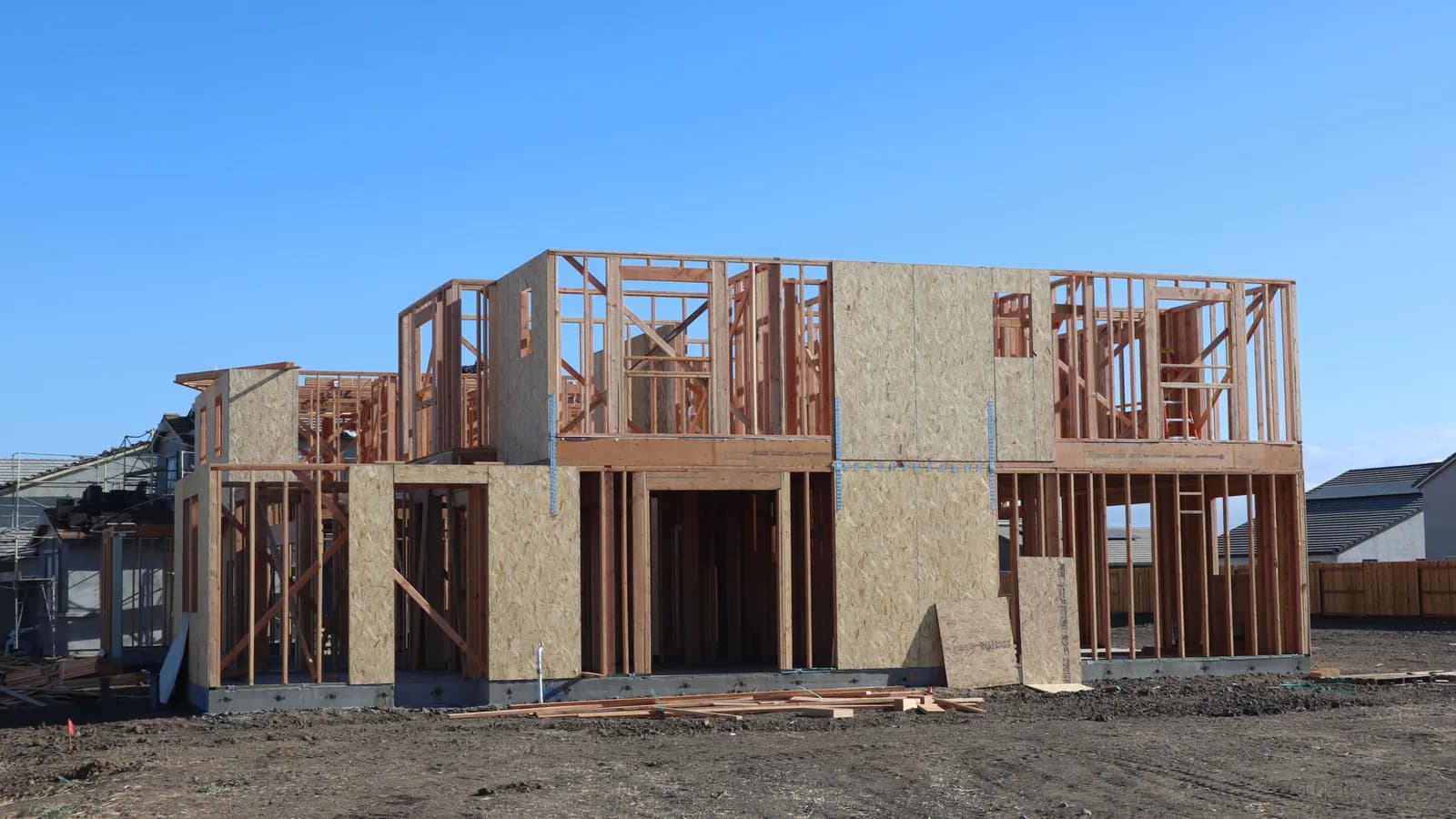 A wooden frame structure under construction for a new suburban house.