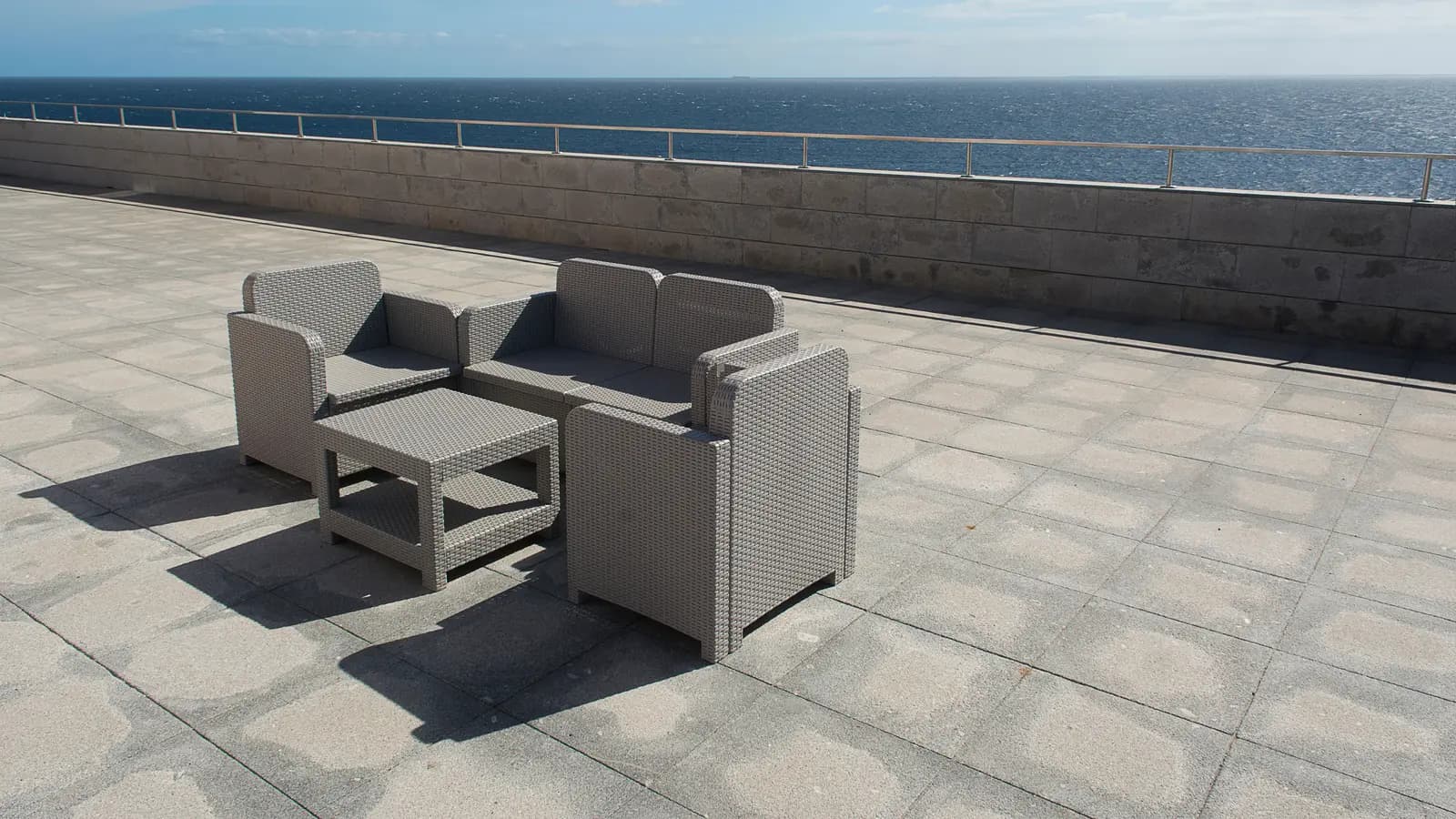 Relaxing outdoor seating area with ocean view on a sunny day.
