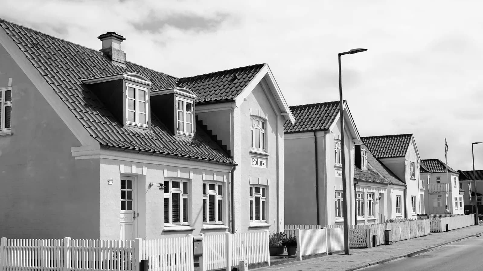 Elegant black and white photo of traditional Danish houses lined along a street.