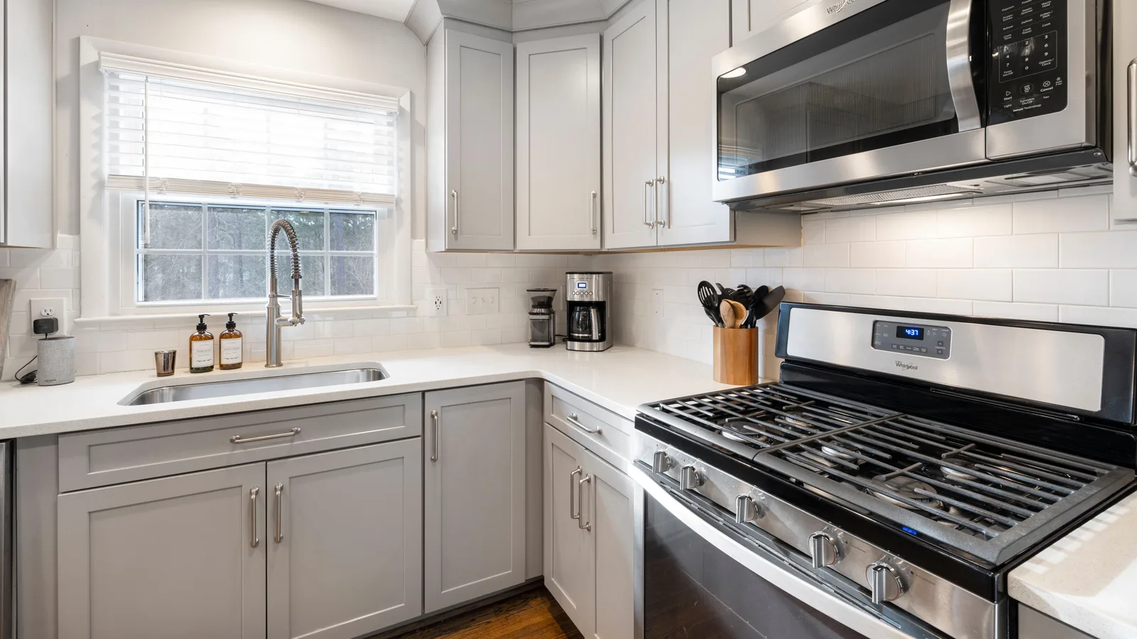 Bright modern kitchen featuring stainless steel appliances and white cabinetry.