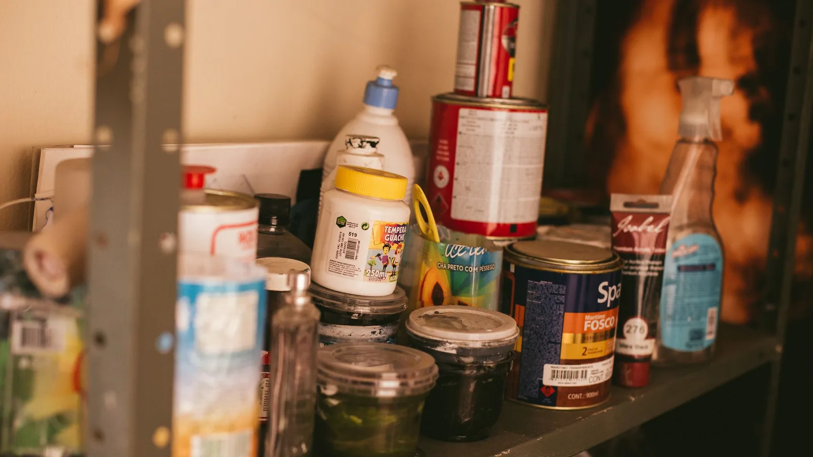 Labeled paint cans stored upright on a dry workshop shelf