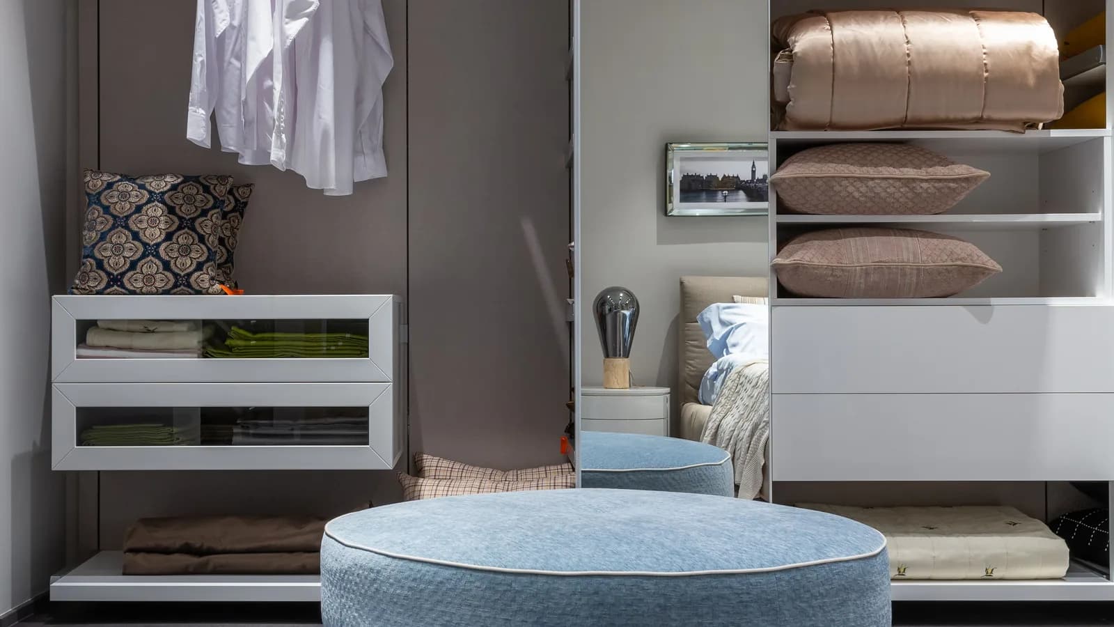 A compact bedroom wardrobe with folded clothing stored above and below the active rail