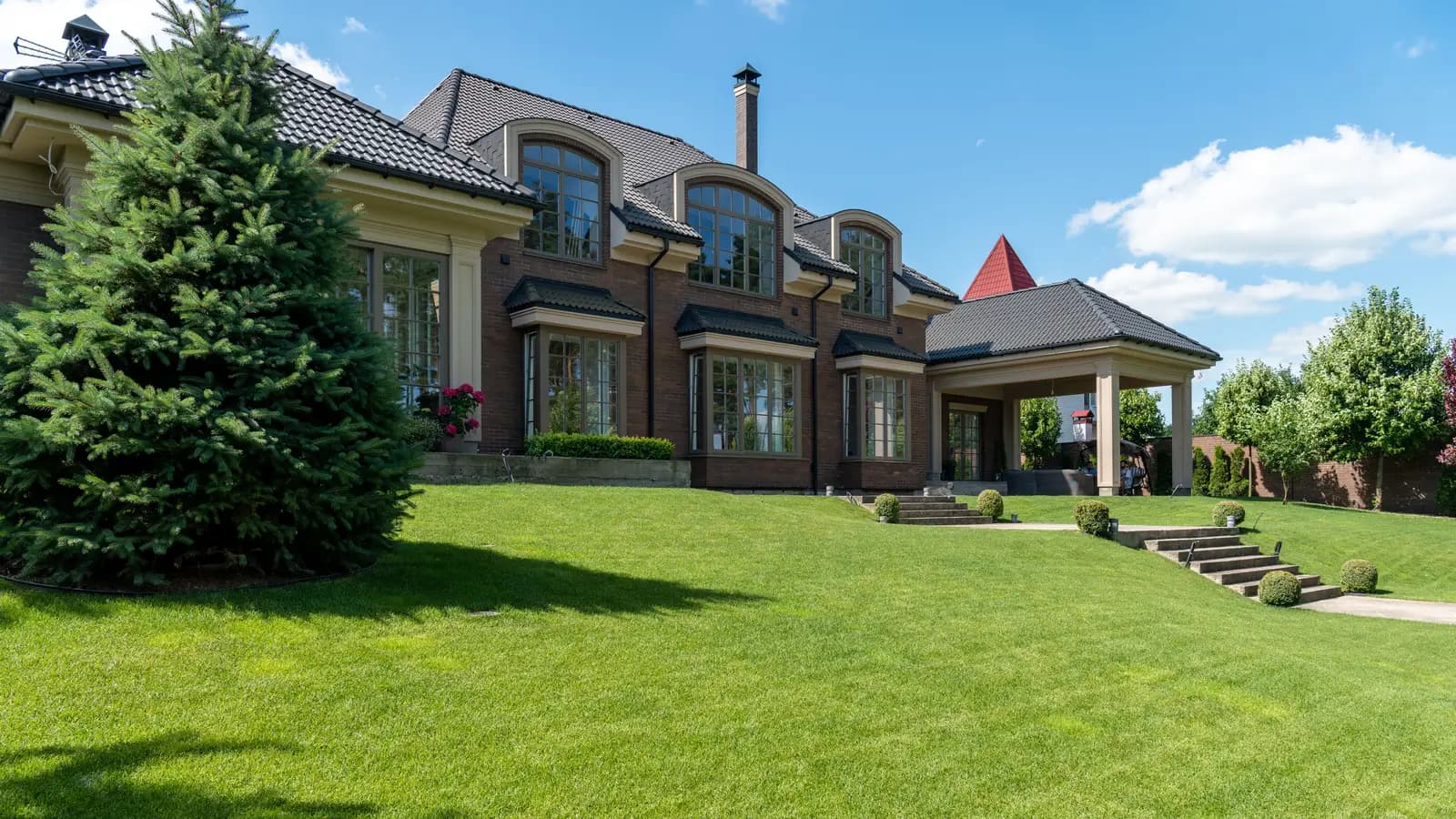 Luxury estate with manicured lawn and modern architectural design on a sunny day.