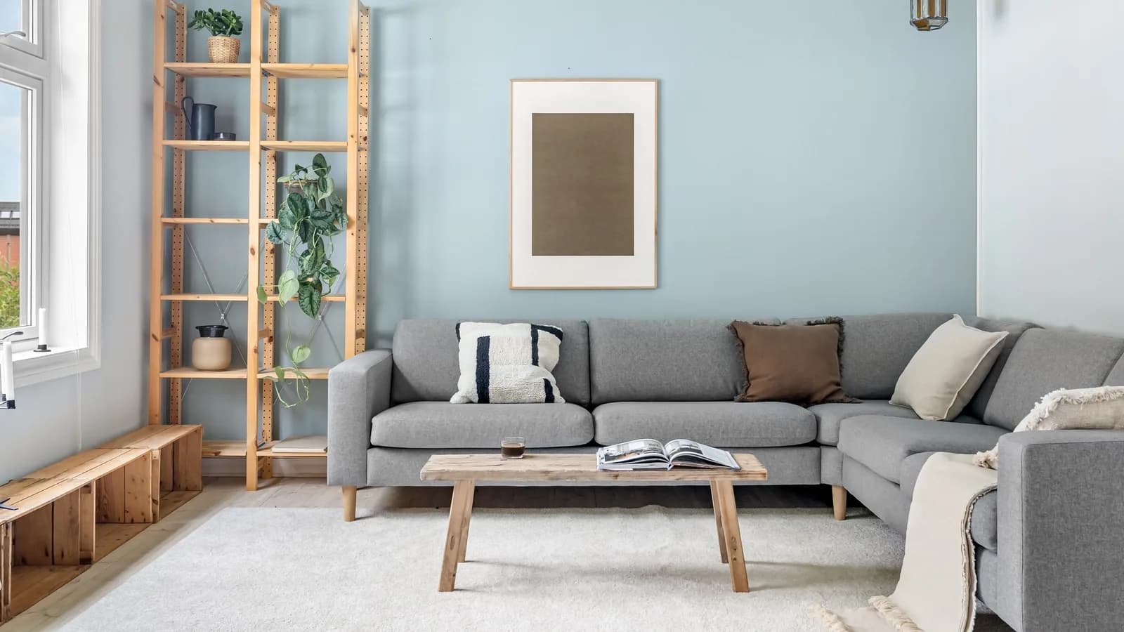 A cozy Scandinavian living room with modern gray couch and wooden elements.