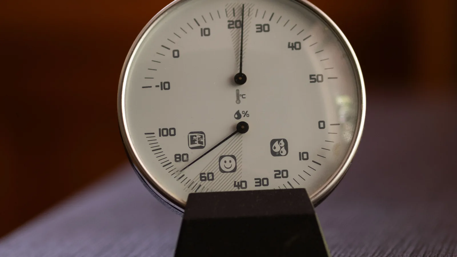 Analog temperature and relative-humidity gauge showing humid indoor air