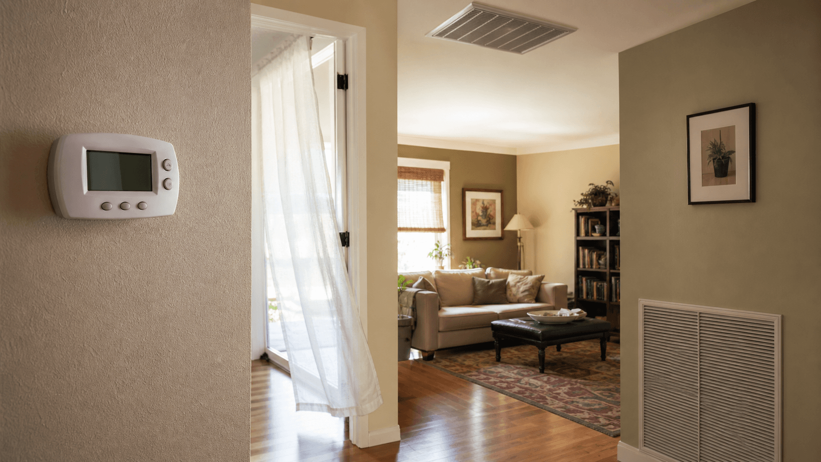 A wall thermostat, ceiling supply register, and return grille in a warm lived-in home