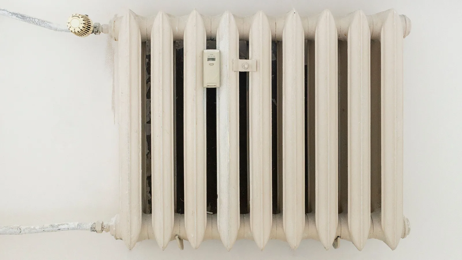 White wall-mounted radiator beneath a window
